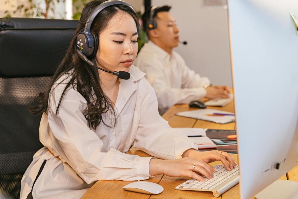 Gaming customer support agent assisting players by taking customer service calls in a professional office environment