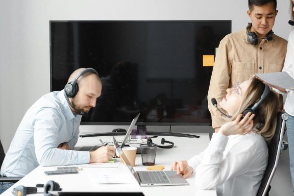 Customer service agents taking calls in a modern office with agent performance monitoring tools