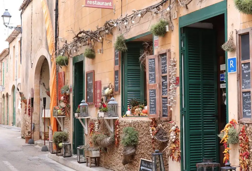 Historic streetscape with cafés, flower displays, and open storefronts